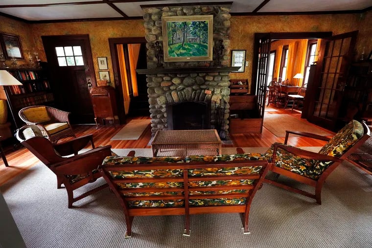 A stone fireplace is a gathering spot in the living room of the Gamer family cottage near Pinecrest Lake in the Poconos. The cottage was built in 1929.