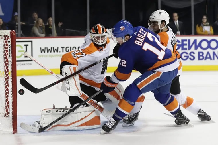 Islanders’ Josh Bailey (12) shoots the puck past Flyers goalie Brian Elliott (left) for the game-winning goal during the overtime period of the Flyers’ 4-3 loss.