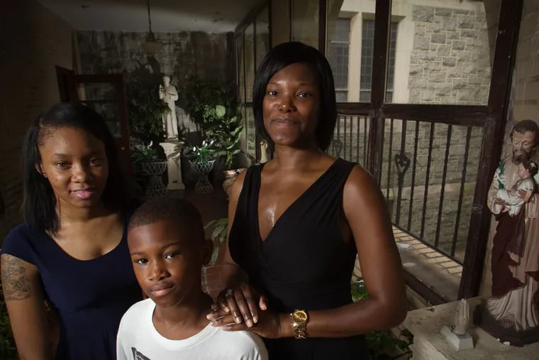 Carla Caple, daughter Aliah Caple, 19, and son Kenneth Washington, 10, at St. Cyprian Church, 525 Cobbs Creek Parkway in Philadelphia on Tuesday, June 23, 2015. She has been moving from church to church and school to school because of mergers and closings. (ALEJANDRO A. ALVAREZ / Staff Photographer)