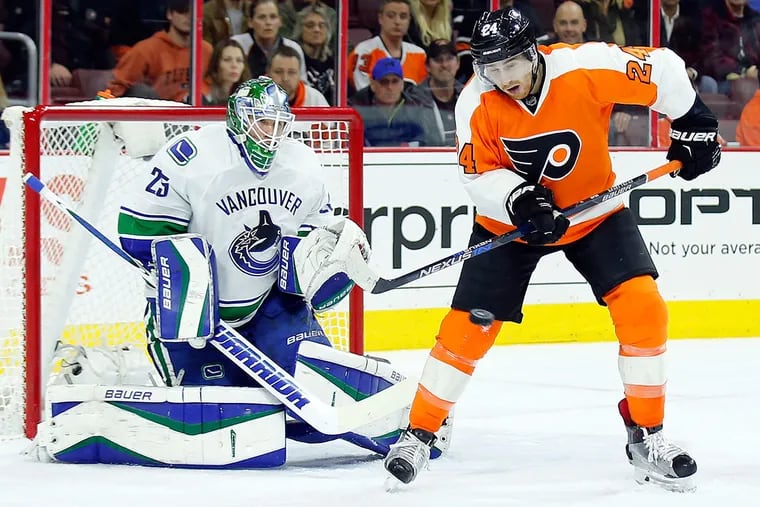 The Flyers' Matt Read watches the puck during a first-period power play against Vancouver and goalie Jacob Markstrom on Thursday.
