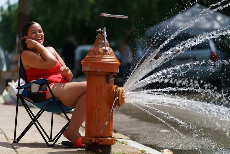 Celinet Velazquez cools off by a fire hydrant in North Philadelphia, July 22, 2020, in Philadelphia.