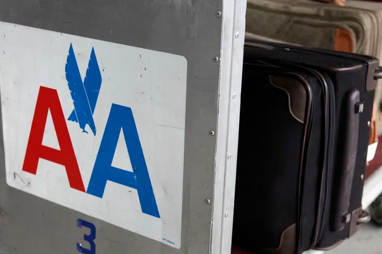 FILE - In this Nov. 29, 2011 file photo, an American Airlines symbol is displayed on the side of a luggage cart at LaGuardia Airport in New York.  American Airlines says it's cutting the cost of checking oversized sporting gear and musical instruments on flights. American said Tuesday, May 21, 2019,  that it eliminated the extra oversize charge for those items and instead will charge regular bag fees, which are lower.  (AP Photo/Seth Wenig, File)