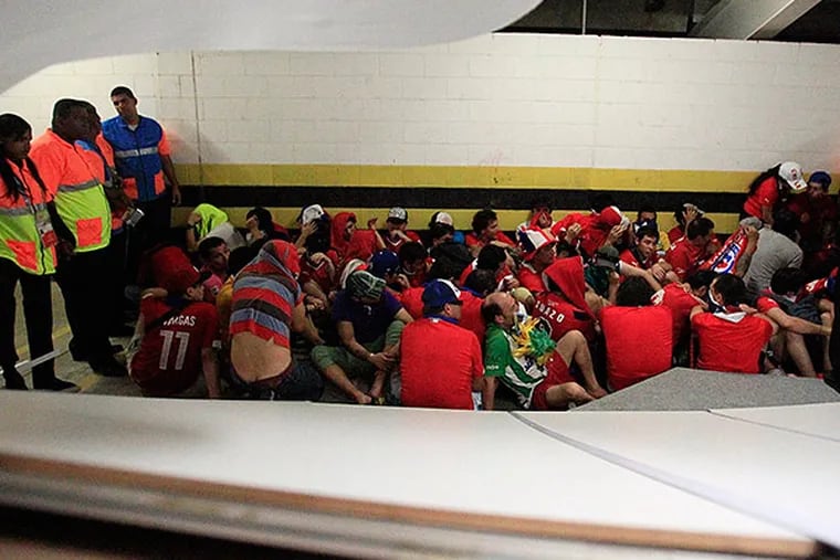 Chile fans without tickets charged through the press center prior to the group B World Cup soccer match between their team and Spain at the Estádio do Maracanã in Rio de Janeiro. (Frank Augstein/AP)