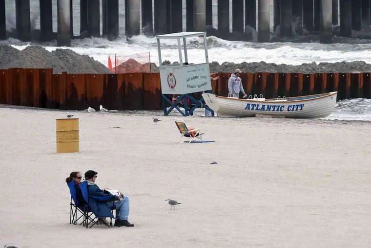 People enjoy the Atlantic City beach on Monday near Resorts and the Taj Mahal casinos as Gov. Christie attended a closed door summit meeting about the future of the gaming town. Story, A1.