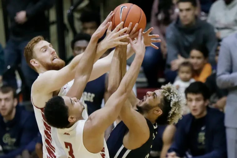 St. Joe's Anthony Longpre (left) scored a career-high 15 points and grabbed 10 rebounds in Saturday's 85-69 loss to George Washington.