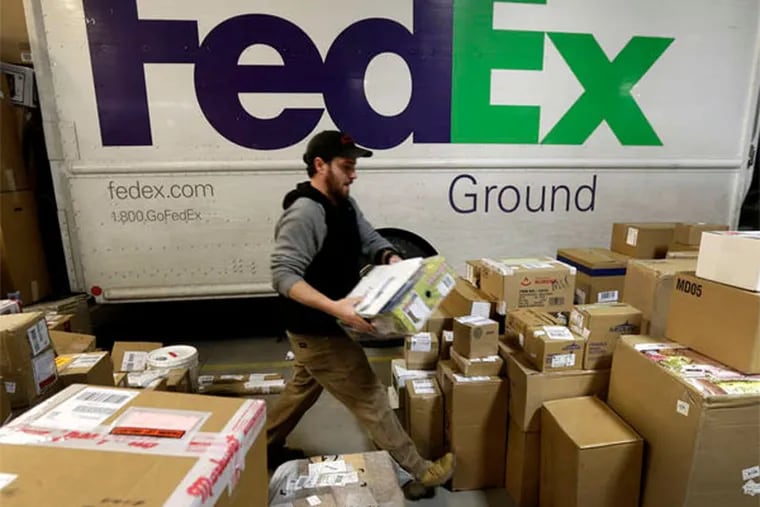 FedEx employee Chris Addison sorts packages in Kansas City, Mo. (AP Photo)