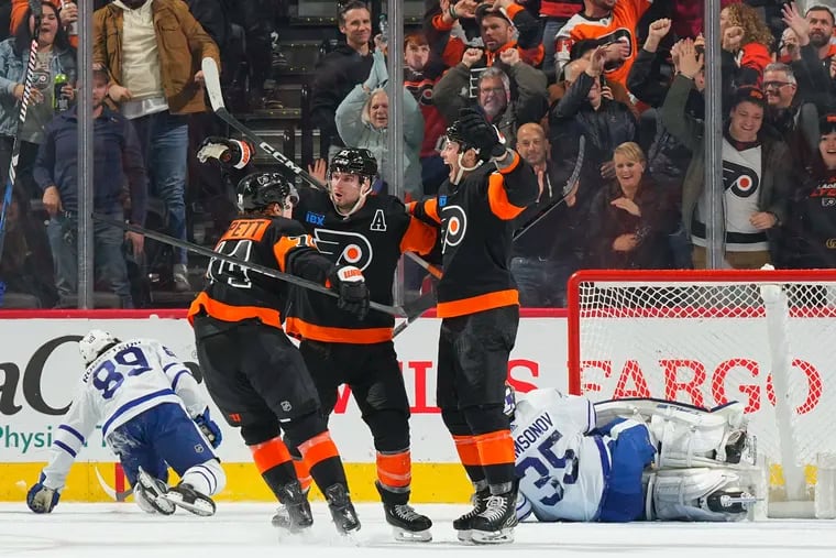 Scott Laughton #21 of the Philadelphia Flyers celebrates with Owen Tippett #74 and Tyson Foerster #71 after scoring a goal against the Toronto Maple Leafs in the third period at the Wells Fargo Center on March 19, 2024 in Philadelphia, Pennsylvania.