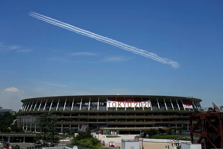 Blue Impulse of the Japan Air Self-Defense Force flies over the main National Stadium in Tokyo, which will host the opening ceremony for the Summer Olympics on Friday.