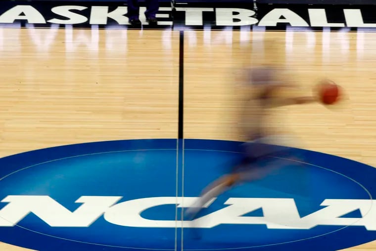 In this March 14, 2012, file photo, a player runs across the NCAA logo during practice at the NCAA tournament college basketball in Pittsburgh. The NCAA Board of Governors took the first step Tuesday toward allowing athletes to cash in on their fame.
