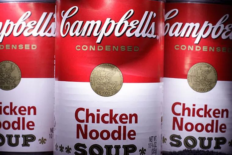 Cans of Campbell's Chicken Noodle Soup are posed in San Diego. Campbell Soup Co. on Tuesday, Nov. 19, 2013 said its quarterly profit fell 30 percent as U.S. sales of soups and V8 beverage declined. A recall of its recently acquired Plum Organics products also hurt results and the company cut its outlook for the year.  (AP Photo/Gregory Bull, File)