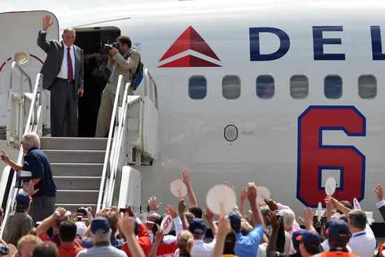 Braves manager Bobby Cox , above, waves to Delta staffers as he boards a charter jet for the road trip to New York. The airline gave him a big send-off, putting his number on the plane. Cox, at left, is in his last season as manager.