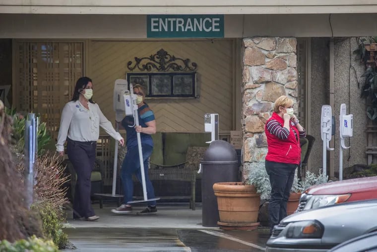 Workers outside the entrance to the Life Care Center nursing home unload supplies, including Purell sanitation stations, on March 2.
