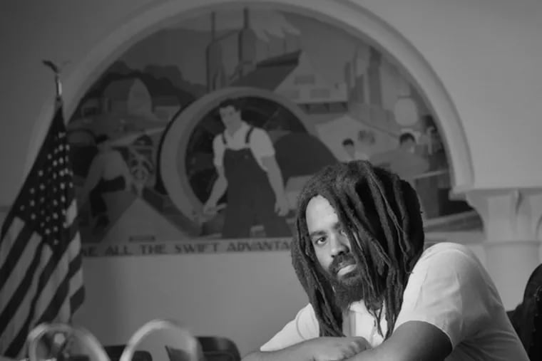 In a scene from &quot;Long Distance Revolutionary: A Journey With Mumia Abu-Jamal,&quot; the subject poses during a visit with photographer Lou Jones. The movie spends very little time on the murder he was convicted of.