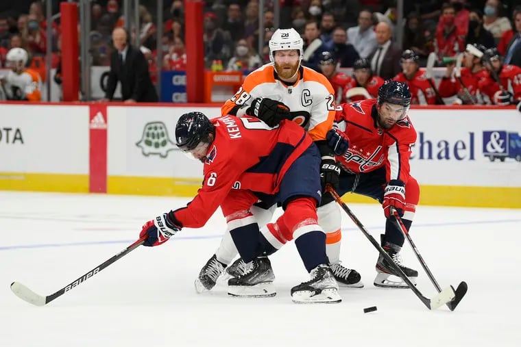 Capitals defensemen Michal Kempny (6) and Justin Schultz (2) separate Flyers captain Claude Giroux from the puck during Friday night's preseason game.