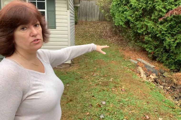 Angela Goodwin of Sellersville points to a runoff ditch in her backyard. The runoff water and her soil were tested for PFAS contamination, which was found in her well water three years ago.