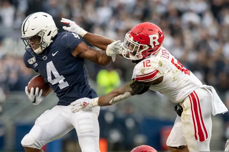 Penn State running back Journey Brown stiff arms Rutgers defensive back Christian Izien in the first quarter.