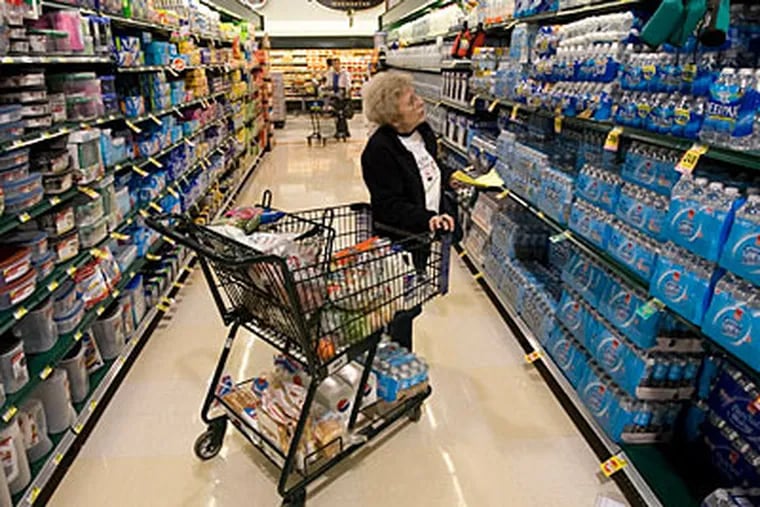 At a Harris Teeter grocery store in North Carolina, Betty Dean comparison-shops for bottled water. To hold down grocery bills, she uses coupons her husband clips. (Shawn Rocco / Raleigh News & Observer)