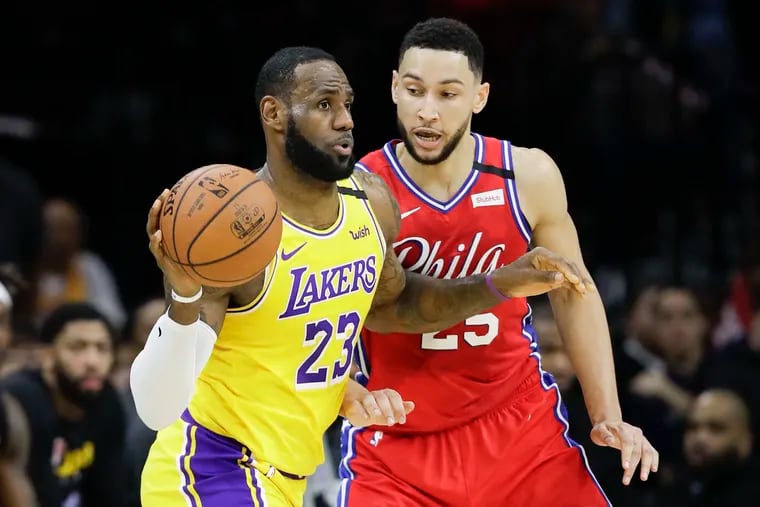 LeBron James passes the ball past Ben Simmons in the second quarter.