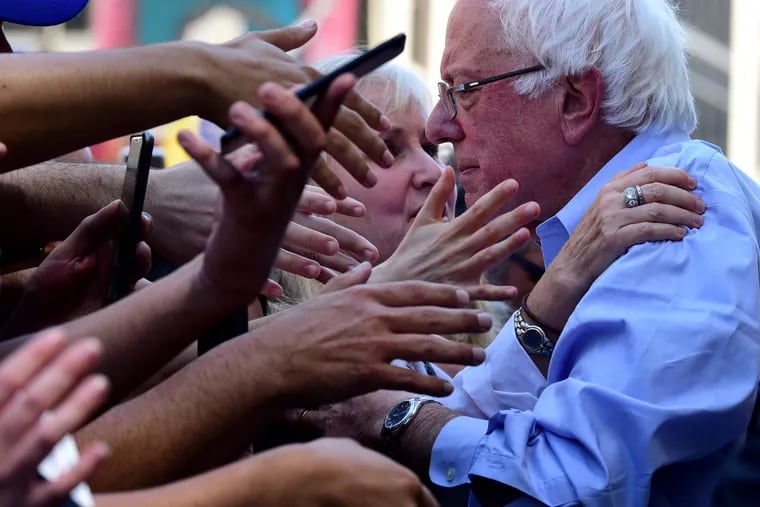 Hands of supporters reach out to Democratic presidential candidate Sen. Bernie Sanders after he spoke at a rally July 15, 2019, at Hahnemann University Hospital, railing against its closure and citing it as an example of why the country needs his Medicare for All plan.
