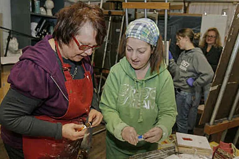 Art professor Kay Klotzbach (left) helps Tina Panna, 37, of Blackwood, with a project. "She inspires me as an artist," said Panna, who returned to school after a career in advertising. (Akira Suwa / Staff Photographer)
