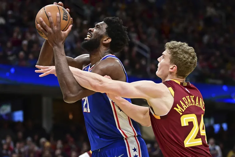 Sixers center Joel Embiid is fouled while going to the basket against Cavaliers forward Lauri Markkanen in the second half.
