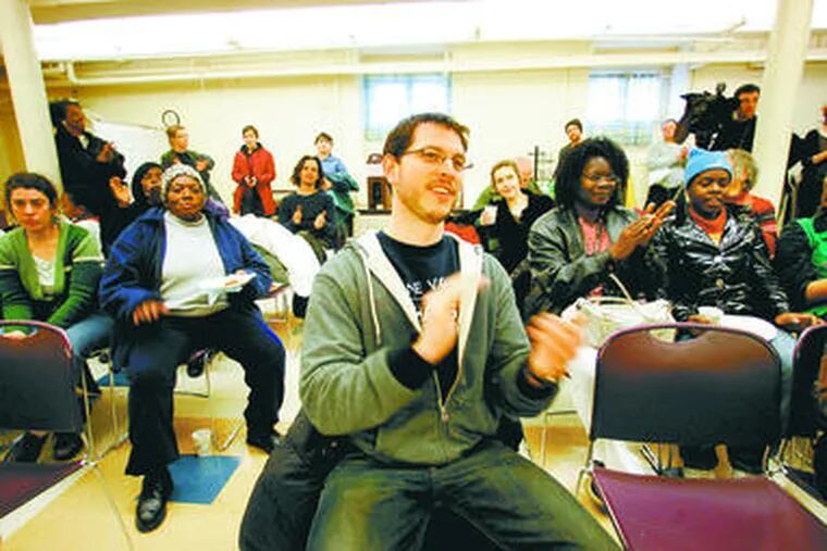 Library supporter Eric Braxton, 33, applauds during a celebration party at the Kingsessing library branch, one of 11 that Mayor Nutter targeted for closure as part of his belt-tightening measures to address a $1 billion five-year budget gap.