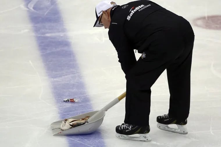 A worker removes a catfish from the ice at PPG Paints Arena in Pittsburgh during the second period of Game 1 of the NHL hockey Stanley Cup Finals between the Pittsburgh Penguins and the Nashville Predators on Monday, May 29, 2017, in Pittsburgh.