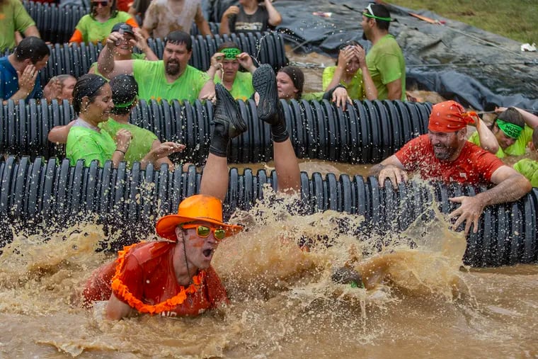 Participants roll over obstacles and into the water during the Muckfest 5k in Glen Mills, PA on Saturday, June 08, 2019. The event is in support of raising money and awareness to Multiple sclerosis (MS) disease.