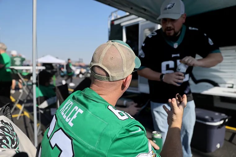 Gary Mann (left), of Shavertown, Pa., wears a Jason Kelce jersey as he tailgates before the Eagles play the Cowboys in Philadelphia on Sunday.