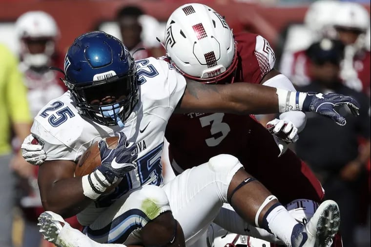 Villanova running back Aaron Forbes is brought down by Temple defensive back Sean Chandler.