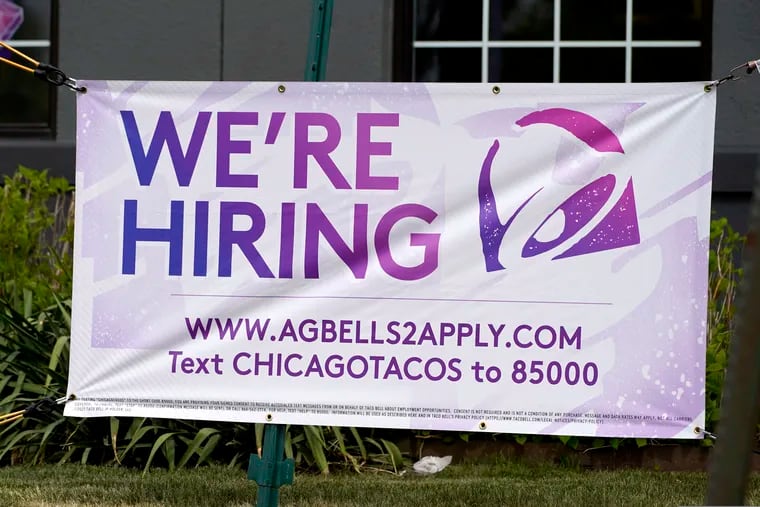 A hiring sign is displayed outside of a restaurant in Glenview, Ill.
