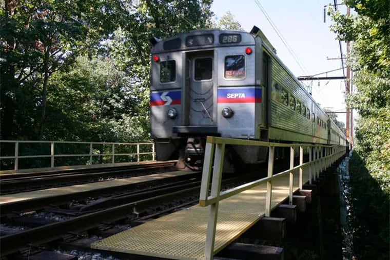 A SEPTA train crosses Swarthmore's Crum Creek bridge, among century-old structures SEPTA can finally replace, thanks to a $2.3B boost in statewide transportation funding. (Charles Fox / Staff Photographer)