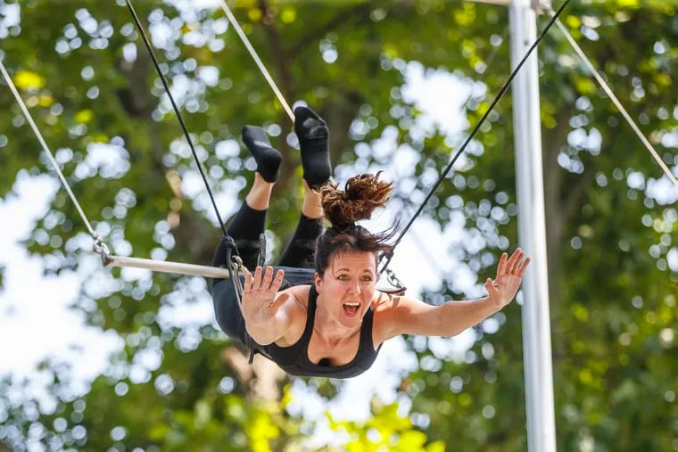 Expressions of surprise and joy, envelope Wendy Ramunno's face as she swings upside down for the first time on a trapeze at the Philadelphia School of Circus Arts on Wednesday August 15, 2018. Philadelphia's first outdoors flying trapeze school is opening on Thursday, August 16, 2018 at the Philadelphia School of Circus Arts.