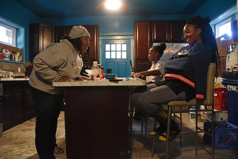 Crystal Brown (left) with daughters Wednesday (center), 7, and Jasmine, 23, in the kitchen of their Germantown house.