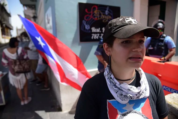 Karla Villalon stands at Fortaleza Street near the executive mansion as she protests against governor Ricardo Rossello, in San Juan, Puerto Rico, Tuesday, July 16, 2019. Protesters are demanding Rossello step down for his involvement in a private chat in which he used profanities to describe an ex-New York City councilwoman and a federal control board overseeing the island's finance.