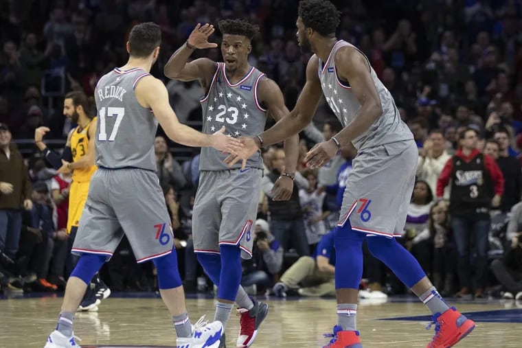 Sixers' guards Jimmy Butler and JJ Redick celebrate with Joel Embiid during the team's win over the Jazz on Friday.