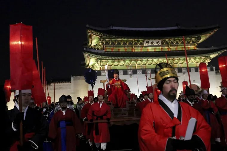 A torch bearer wearing traditional costumes carries the torch during the Olympic Torch Relay in Seoul, South Korea, Saturday, Jan. 13, 2018. South Korea said Saturday that North Korea proposed that their talks next week address a North Korean art troupe’s visit to the Pyeongchang Winter Olympics in the South, rather than the participation of the nation’s athletes.