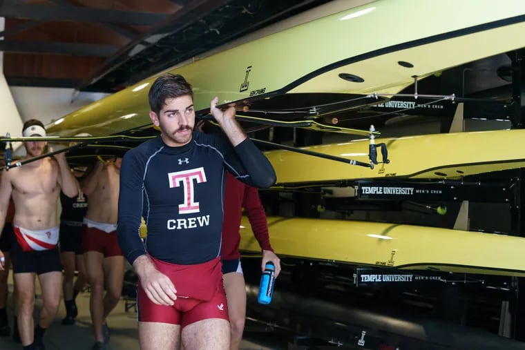Temple rower Stephen Gannaro, front, helps his crew carry a boat toward the water at the Temple Boathouse earlier this month.