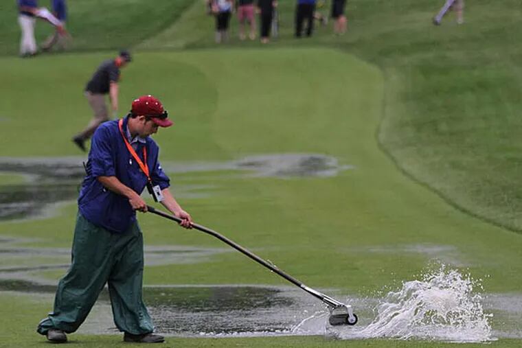 A grounds worker uses a squeegee to dry the 16th fairway at Merion. (Michael Bryant/Staff Photographer)