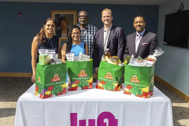 Ride-sharing service Lyft has launched a six-month pilot program to transport residents of designated PHA sites to grocery stores, for a flat fee of $2.50 each way. Pictured above are (from left to right): Lopa P. Kolluri, PHA Senior EVP; PA State Rep. Donna Bullock; PHA resident Alfred Dukes; Lyft regional director Andrew Woolf; and Uplift Solutions executive director Atif Bostic.