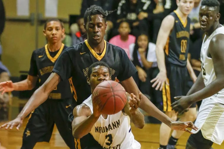 Neumann-Goretti’s Dymir Montague passes the ball past Archbishop Wood’s Seth Pinkney on Friday.