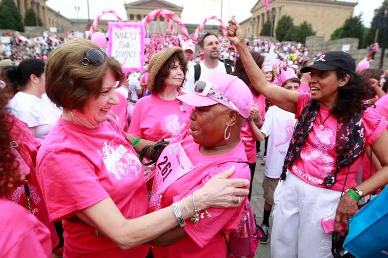 Toni Glitz (left), a 17-year cancer survivor, embraces Betty Willis, a four-year survivor, during the survivors' parade at the Art Museum on Sunday, part of the annual Susan G. Komen Philadelphia Race for the Cure.