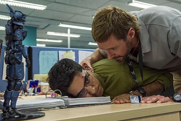 Dev Patel (left) and Hugh Jackman play robot-designing engineers in the futuristic tech thriller &quot;Chappie.&quot; (STEPHANIE BLOMKAMP)