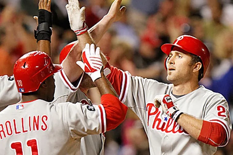 Chase Utley is congratulated after hitting a grand slam in the 7th inning of last night's 12-11 win. (AP Photo/Barry Gutierrez)