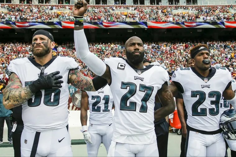 Eagles strong safety Malcolm Jenkins raises his fist with teammate defensive end Chris Long (left) and free safety Rodney McLeod during the National Anthem before the played the Washington Redskins on Sept. 10 in Landover, Md. Y