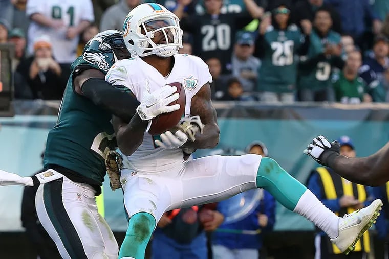 Malcolm Jenkins tries to knock the ball away from the Dolphins' Jarvis Landry.