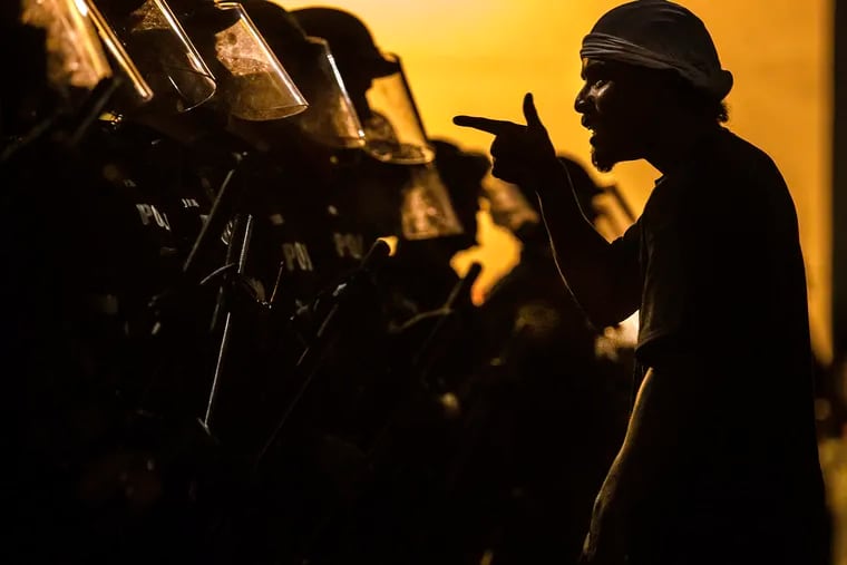 A protester vents at a line of Tucson Police Officers in riot gear at Cushing Street and Church Avenue early on Saturday, May 30, 2020 in Tucson. The protest in Tucson was similar to those in numerous cities across the United States following George Floyd's death while in custody of the Minneapolis police on Memorial Day in Minnesota. (Josh Galemore/Arizona Daily Star via AP)