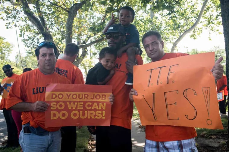 Laborers' International Union of North America member Jack Barbosa (left) stands next to fellow members Jermaine Sumlin, holding his son Aiden, 2, on his shoulders and Asa, 3, and Joe Tuccillo outside the office of Sen. James Beach in Cherry Hill on Wednesday, Aug. 17, 2016.