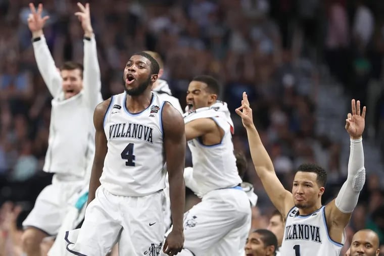 Eric Paschall (center), Jalen Brunson (right) and the Villanova bench celebrate after a Donte DiVincenzo three-pointer against Michigan during the second half of the NCAA championship game on Monday.