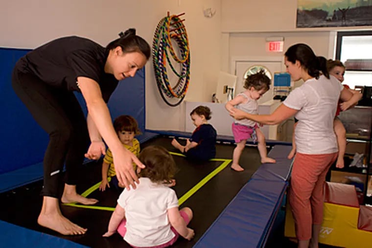 Marissa Pellegrino, left works with toddlers and their parents during an exercise class at Relentless Fitness in South Philadelphia .( Ed Hille / Staff Photographer)
117678